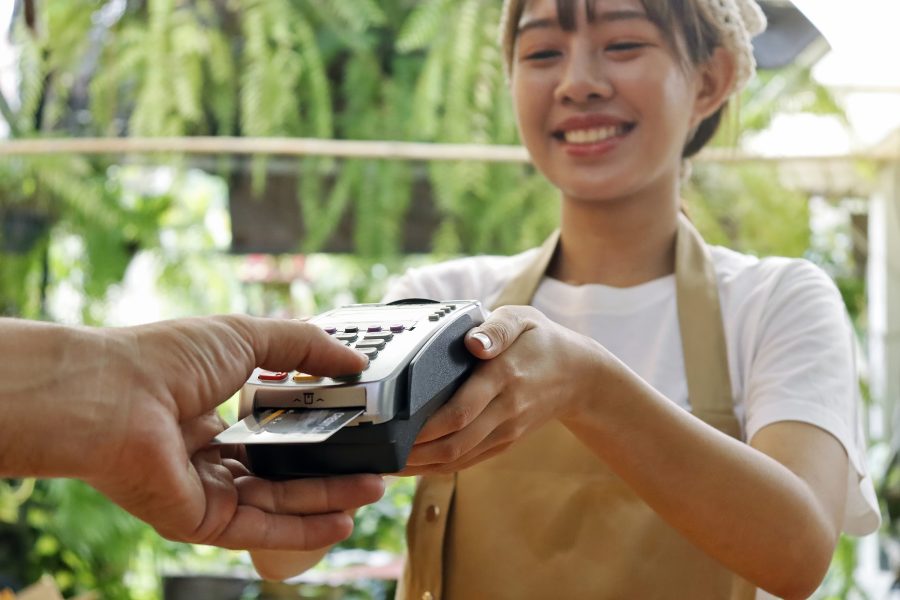 A staff member at a restaurant presents a customer with a payment terminal for payment.